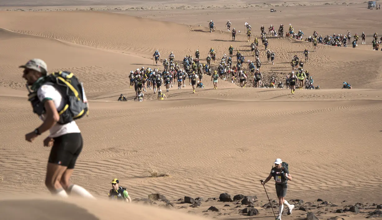 Peserta ambil bagian dalam kejuaraan Marathon des Sables ke-33 tahap kedua di Gurun Sahara, Maroko, Senin (9/4). Pada awalnya lomba ini hanya diikuti 23 peserta, tetapi sekarang lebih dari 12 ribu peserta tertarik untuk ikut. (JEAN-PHILIPPE KSIAZEK/AFP)