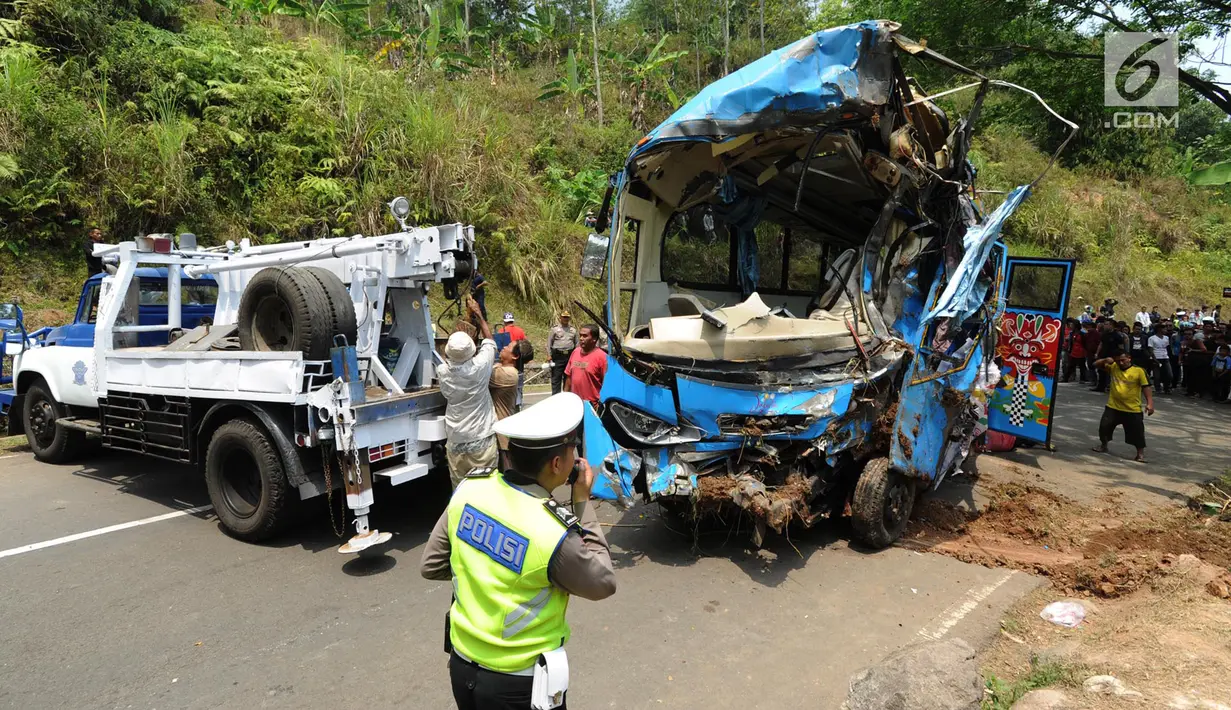 Bangkai bus maut Jakarta Wisata Transport berhasil diangkat dari jurang menggunakan derek di jalur alternatif Cikidang, Sukabumi, Jawa Barat, Minggu (9/9). Akibat kecelakaan bus masuk jurang tersebut, 21 orang dinyatakan tewas. (Merdeka.com/Arie Basuki)