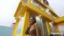 Tim Kapanlagi mendapatkan kesempatan menyambangi rumahnya. Senyum Rey Utami di depan rumahnya yang tampak megah dengan cat kuning. [Foto: KapanLagi.com®/Budy Santoso]
