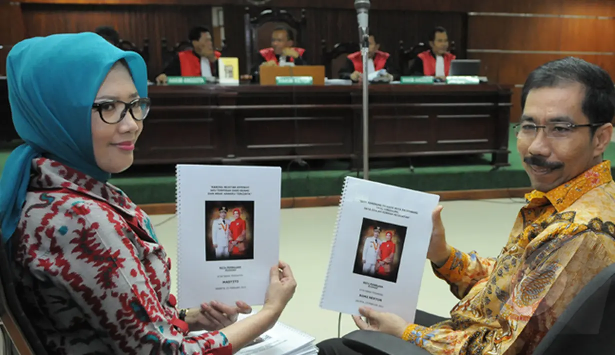 Romi Herton dan Masyito memperlihatkan salinan naskah kepada wartawan saat sidang kasus dugaan suap penanganan sengketa pilkada Kota Palembang di Pengadilan Tipikor, Jakarta, Senin (23/2/2015).  (Liputan6.com/Herman Zakharia)