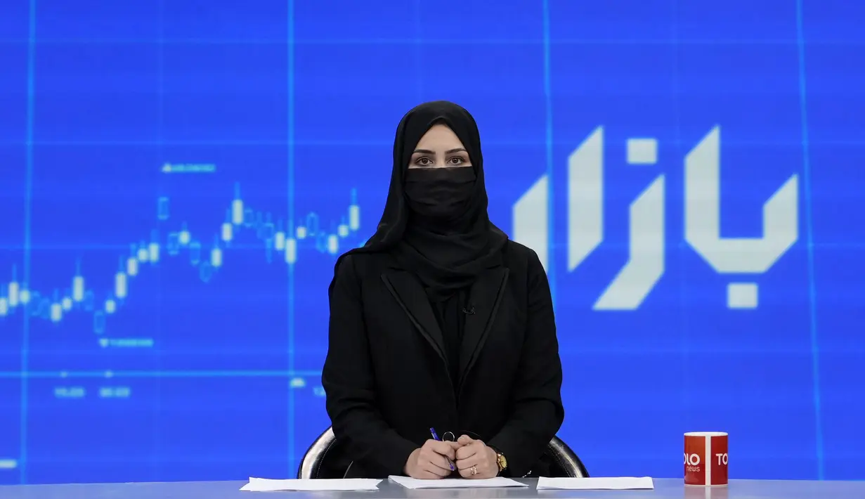 <p>Khatereh Ahmadi, seorang presenter televisi mengenakan penutup wajah saat membacakan berita di TOLO NEWS, di Kabul, Afghanistan, Minggu, 22 Mei 2022. Taliban mulai mewajibkan semua presenter atau pembawa acara televisi perempuan menutupi wajah mereka saat siaran. (AP Photo/Ebrahim Noroozi)</p>