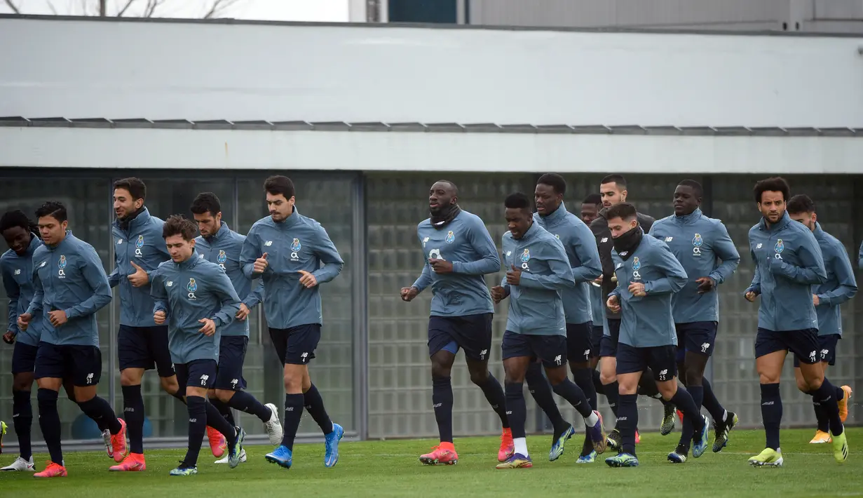 Para pemain FC Porto melakukan pemanasan saat mengikuti sesi latihan tim di tempat latihan Olival di Vila Nova de Gaia (16/2/2021). Porto akan bertanding melawan Juventus pada leg pertama babak 16 besar Liga Champions di Estadio do Dragao. (AFP/Miguel Riopa)