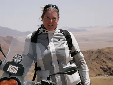 Alisa Clickenger berpose dengan sepeda motornya saat berada di Namibia, Afrika pada Oktober 2014. Sejak tahun 2009, Clickenger sudah melakukan tur lintas negara menggunakan sepeda motornya seorang diri. (Courtesy of Alisa Clickenger via AP)