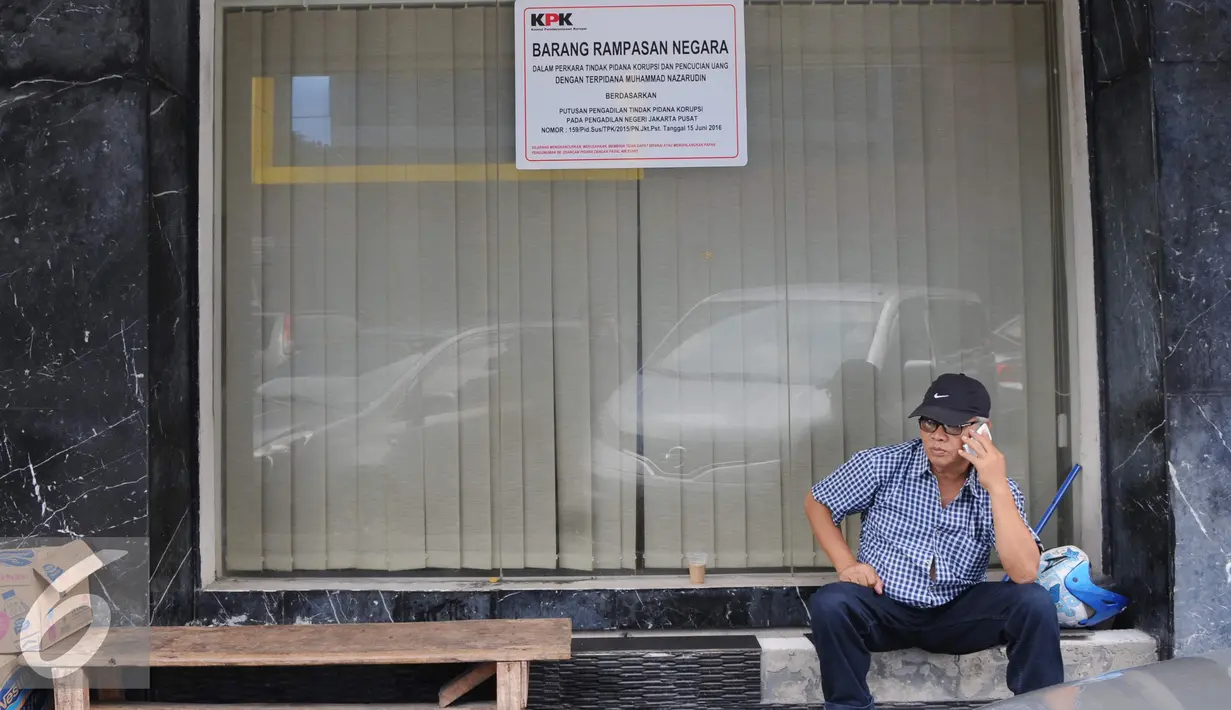 Seorang warga duduk di depan ruko Nazaruddin yang sudah ditempel pemberitahuan segel di Wijaya Grand Center, Jakarta Selatan, Senin (28/11). Ruko tersebut masuk dalam daftar kekayaan Nazaruddin yang dirampas negara. (Liputan6.com/Helmi Affandi)