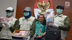 Petugas menunjukkan barang bukti uang hasil OTT di Bengkulu, ketika konferensi pers di KPK, Jakarta, Rabu (21/6). KPK menyita uang Rp 1 miliar dalam kardus di rumah Gubernur Bengkulu Ridwan Mukti saat operasi tangkap tangan.  (Liputan6.com/Helmi Afandi)