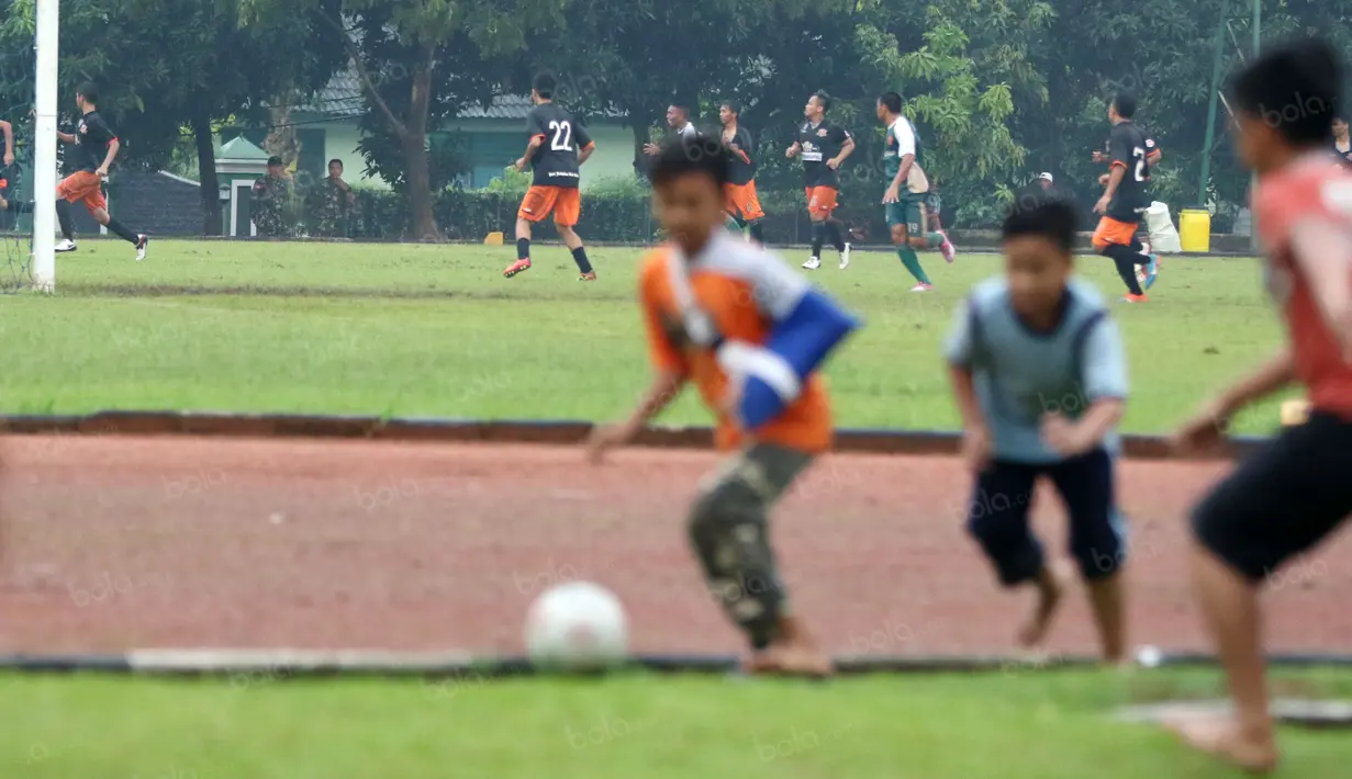 Anak-anak menikmati bermain bola saat laga uji coba PS TNI melawan Villa 2000 di Lapangan Mako Kostrad, Cilodong, Depok, Rabu (13/4/2016). (Bola.com/Nicklas Hanoatubun)