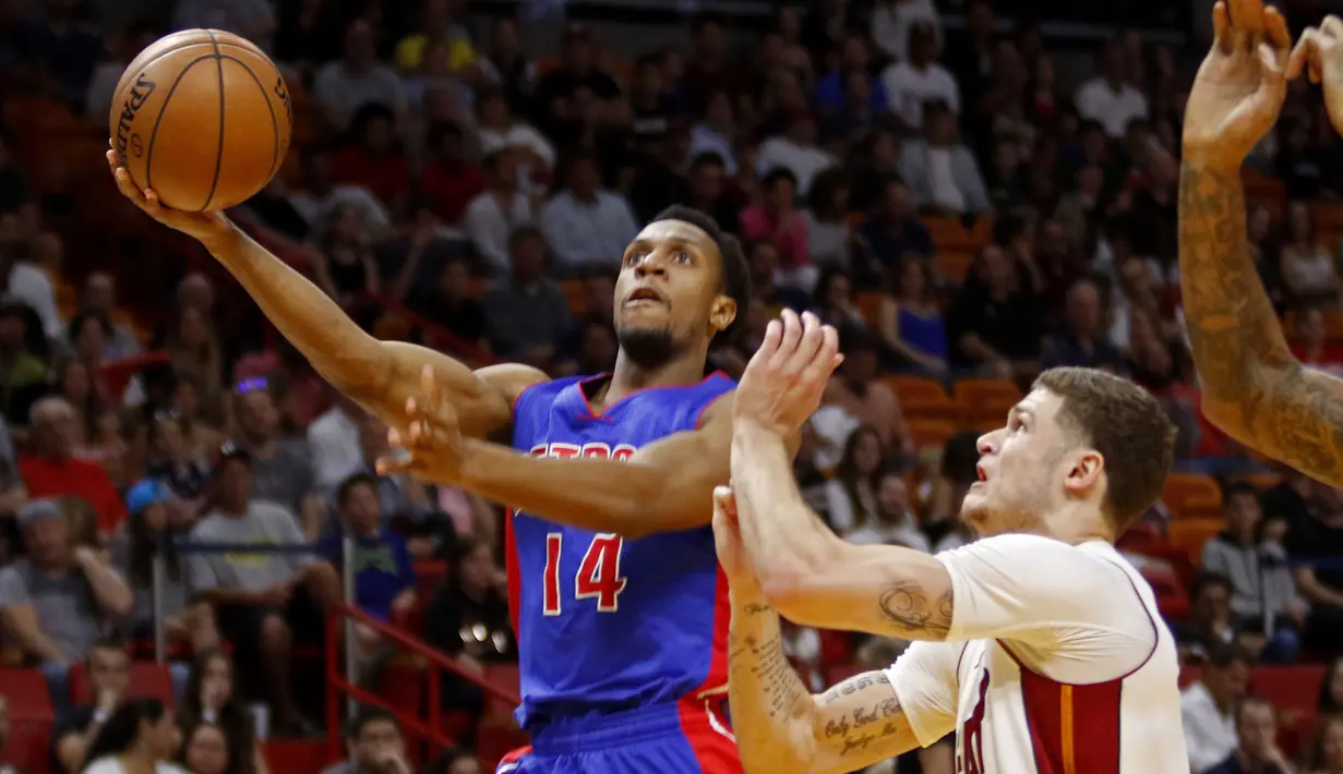 Pemain Detroit Pistons Ish Smith (kiri) melakukan tembakan melewati hadangan pemain Miami Heat, Tyler Johnson (kanan) pada laga NBA di American Airlines Arena, Miami, (01/01/2017). Pistons menang 107-98. (AP/Joe Skipper)