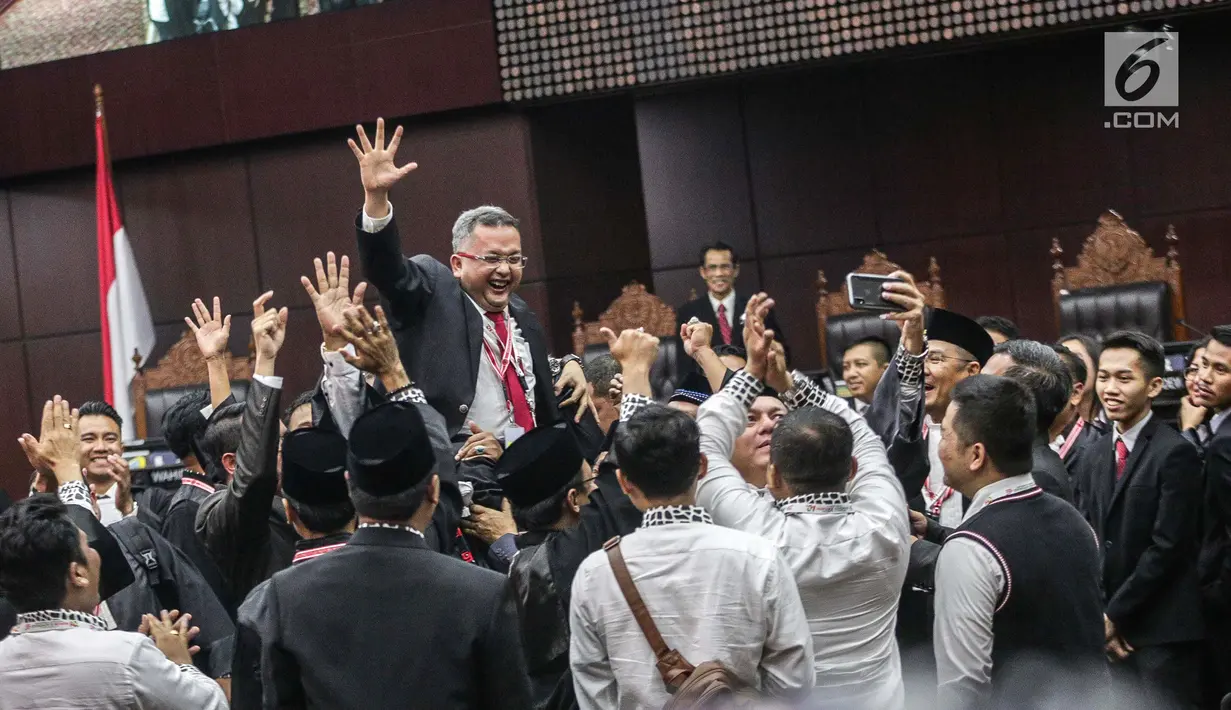 Anggota Tim Hukum Jokowi-Ma'ruf Amin, Trimedya Panjaitan bereuforia usai putusan MK di Gedung MK, Jakarta, Kamis (27/6/2019). MK menolak seluruh gugatan hasil Pilpres 2019 yang diajukan Prabowo-Sandiaga Uno yang disepakati 9 hakim konstitusi tanpa dissenting opinion. (Liputan6.com/Faizal Fanani)