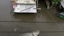 Warga menggunakan perahu melintasi genangan banjir yang merendam Asuncion, Paraguay, Senin (28/12). Banjir terparah dalam kurun waktu 23 tahun ini, bahkan telah membuat lebih dari 100.000 warga mengungsi. (REUTERS/Jorge Adorno)