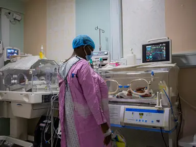 Safina Namukwaya, 70, memeriksa bayi kembarnya di dalam inkubator di Women's Hospital International and Fertility Centre setelah melahirkan di Kampala, Minggu (3/12/2023). (BADRU KATUMBA / AFP)
