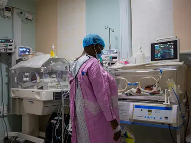 Safina Namukwaya, 70, memeriksa bayi kembarnya di dalam inkubator di Women's Hospital International and Fertility Centre setelah melahirkan di Kampala, Minggu (3/12/2023). (BADRU KATUMBA / AFP)