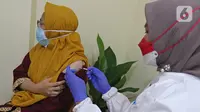 Vaksinator menyuntikkan vaksin Covid-19 dosis ketiga atau booster kepada tenaga medis di RSUD Matraman, Jakarta, Jumat (6/8/2021). Pemberian vaksin dosis ketiga kepada tenaga kesehatan di Indonesia ditargetkan rampung pada pekan kedua Agustus 2021 (Liputan6.com/Herman Zakharia)