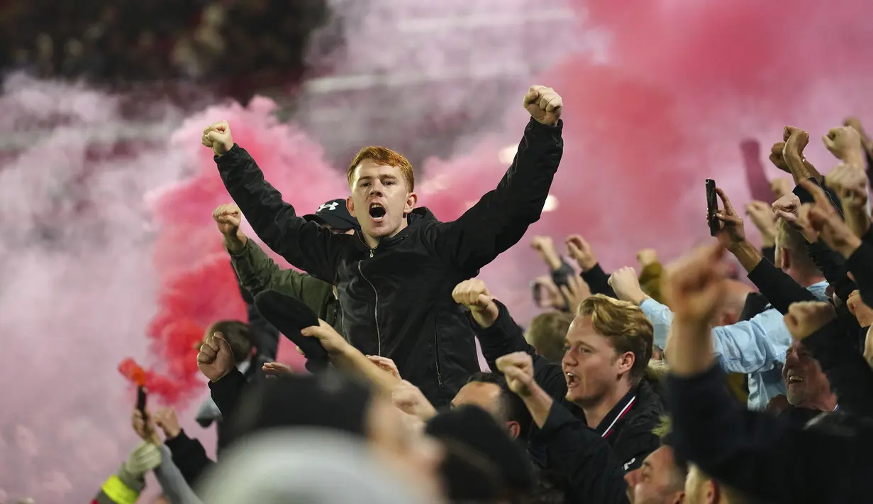 Para fans Manchester United menyalakan flare saat merayakan kemenangan 2-1 timnya atas Sheffield United setelah berakhirnya laga pekan ke-9 Liga Inggris 2023/2024 di Bramall Lane, Sheffield, Minggu (22/10/2023) dini hari WIB. (AP Photo/Jon Super)