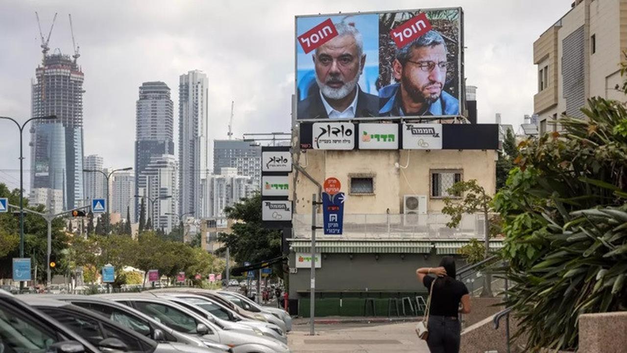 Papan iklan di Tel Aviv, Israel, memajang potret pemimpin Hamas Mohammed Deif dan Ismail Haniyeh dengan tulisan "dibunuh" dalam bahasa Ibrani, pada 2 Agustus 2024.