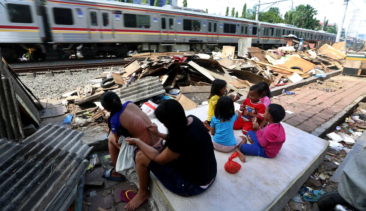 Warga beraktivitas didekat puing bongkaran rumah di area Rusun Bendungan Hilir (Benhil) II, Jakarta, Minggu (3/12). (Liputan6.com/JohanTallo)