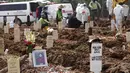 Potret seorang wanita diletakkan di kuburannya di TPU Rorotan yang diperuntukkan bagi mereka yang meninggal karena COVID-19, Jakarta, Rabu (7/7/2021). Indonesia menghadapi gelombang kedua COVID-19. (AP Photo/Tatan Syuflana)