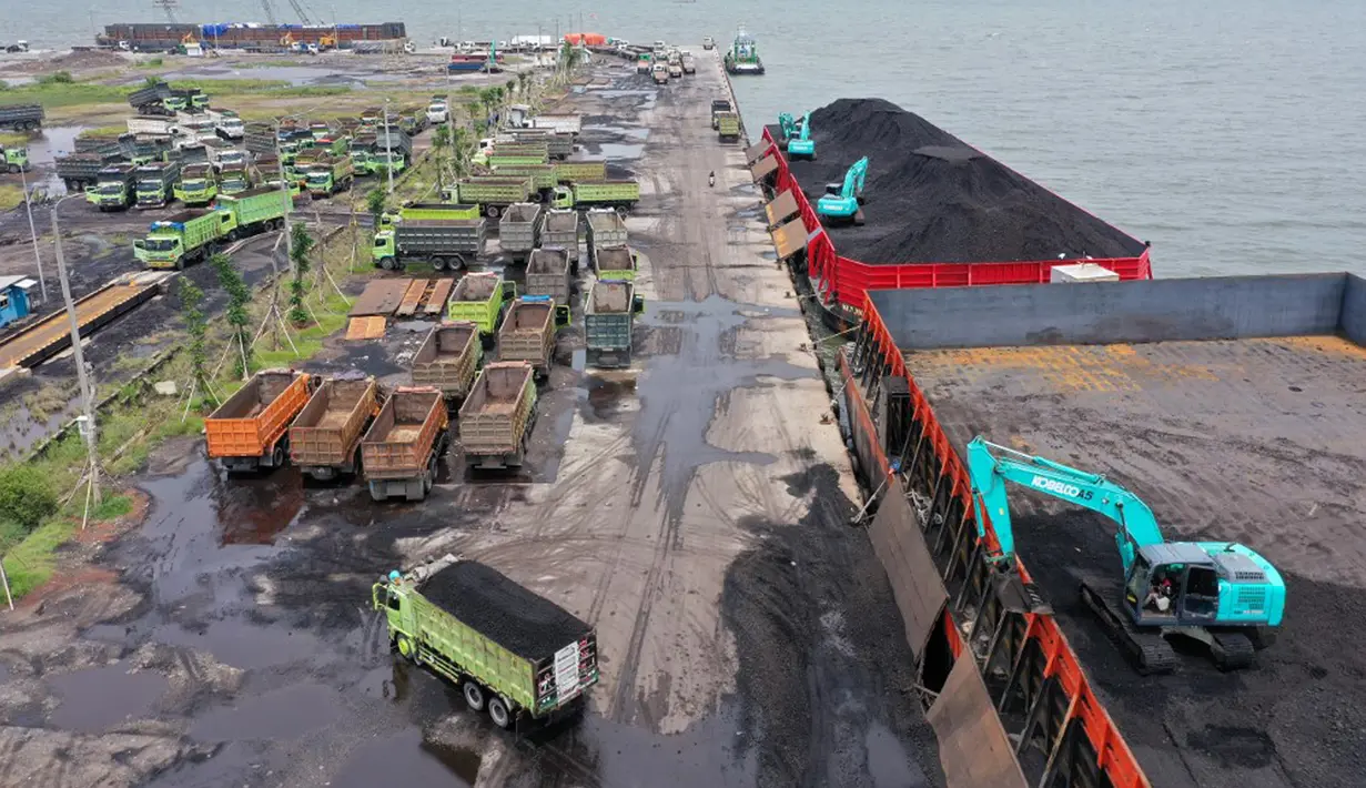 Alat berat (kanan) digunakan untuk memuat batu bara ke truk di Pelabuhan Karya Citra Nusantara (KCN) Marunda, Jakarta, 17 Januari 2022. Indonesia melonggarkan larangan ekspor batu bara. (ADEK BERRY/AFP)