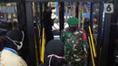 Personil TNI saat turun dari bus TransJakarta di Halte TransJakarta Tosari, Jakarta, Rabu (1/3/2023). PT TransJakarta menempatkan petugas TNI menyusul maraknya kasus pelecehan seksual yang dilakukan penumpang laki-laki kepada penumpang perempuan di dalam bus. (Liputan6.com/Herman Zakharia)