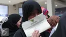 Seorang TKI memperlihatkan surat perjalanan pada wartawan di Bandara Soekarno Hatta,Tangerang, Rabu (11/11). Sebanyak 450 WNI overstayers dan TKI undocumented dari Jeddah, Arab Saudi dipulangkan pemerintah Indonesia. (Liputan6.com/Angga Yuniar)