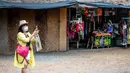 Seorang turis yang mengenakan masker mengambil gambar di luar kios suvenir di Taman Chang Siam, Pattaya, Thailand, Rabu (12/2/2020). Chang Siam Park adalah salah satu primadona bagi wisatawan China di Pattaya  yang kini berangsur sepi karena penyebaran virus corona covid-19. (Mladen ANTONOV / AFP)