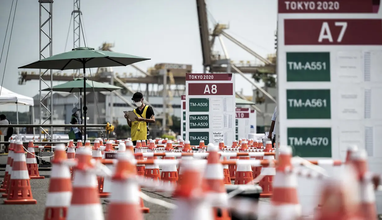Seorang relawan menunggu di terminal bus pada 20 Juli 2021 di Tokyo, tiga hari sebelum upacara pembukaan Olimpiade Tokyo 2020. (AFP/Jeff Pachoud)
