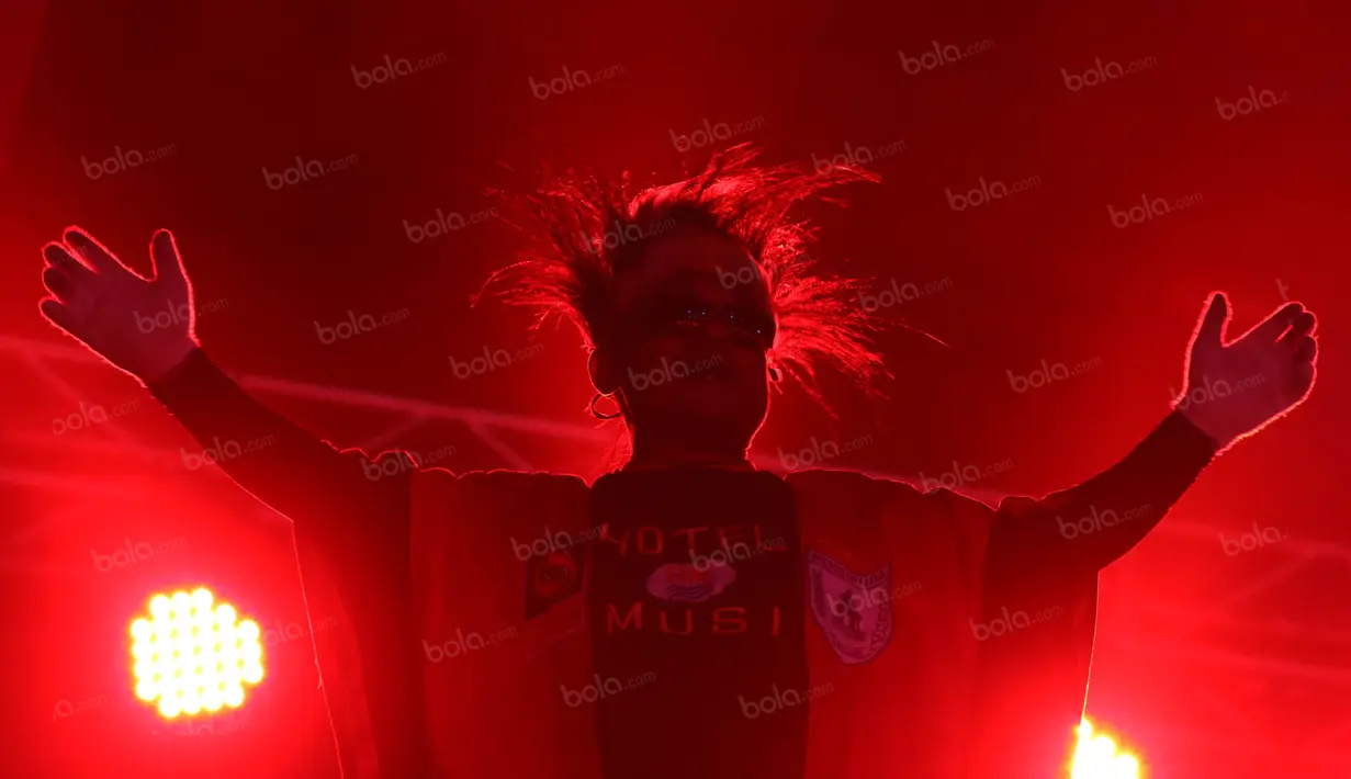 Seorang Persipura Mania jubah panjang memimpin rekan-rekannya memeriahkan laga pembuka Torabika Soccer Championship 2016 di Stadion Mandala, Jayapura, Papua, Jumat (29/4/2016). (Bola.com/Nicklas Hanoatubun)