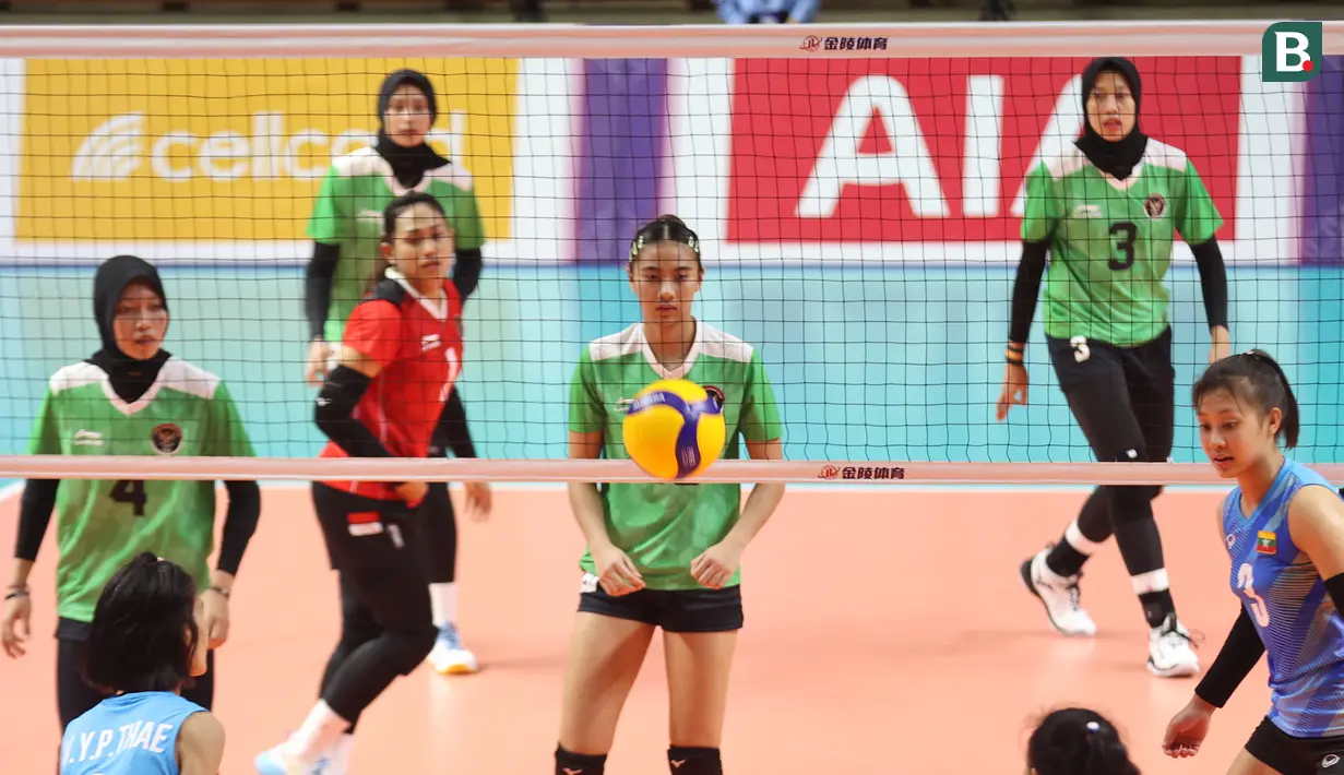 Para pemain bola voli putri Myanmar berusaha mengembalikan bola saat menghadapi tim bola voli putri Indonesia pada laga ketiga Grup A SEA Games 2023 di Olympic Complex Indoor Stadium, Phnom Penh, Kamboja, Kamis (11/5/2023). Tim bola voli putri Myanmar kalah 0-3 (9-25, 9-25, 15-25). (Bola.com/Abdul Aziz)