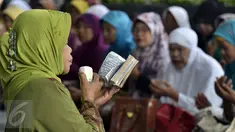 Seorang wanita tampak memimpin doa di depan gedung KPK, Jakarta, Rabu (17/6/2015). Mereka mendoakan Mantan Menteri Agama Suryadharma Ali agar mendapatkan penangguhan penahanan. (Liputan6.com/Helmi Afandi)