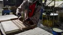 Seorang pekerja membuat tahu dari kedelai di sebuah fasilitas di Banda Aceh (12/10/2020). (AFP Photo/Chaideer Mahyuddin)