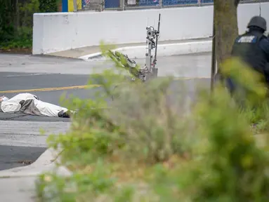 Seorang pria yang mengenakan kostum panda tergeletak di jalan usai ditembak oleh polisi di luar stasiun televisi Fox 45 di Baltimore, Amerika Serikat (AS), Kamis (28/4). Pria itu mengancam akan meledakkan stasiun televisi Fox 45. (REUTERS/Bryan Woolston)