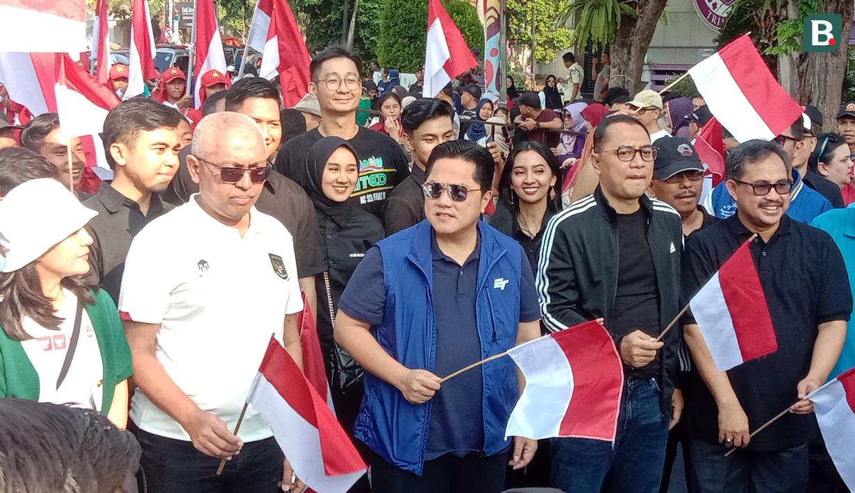 Ketua Umum PSSI, Erick Thohir (tengah), didampingi Wali Kota Surabaya, Eri Cahyadi (dua kanan) saat mengikuti pawai yang dilakukan mulai area Siola menuju Balai Pemuda Surabaya dalam rangkaian acara Trophy Experience Piala Dunia U-17 2023 di Surabaya, Minggu (29/10/2023). (Bola.com/Aditya Wany)