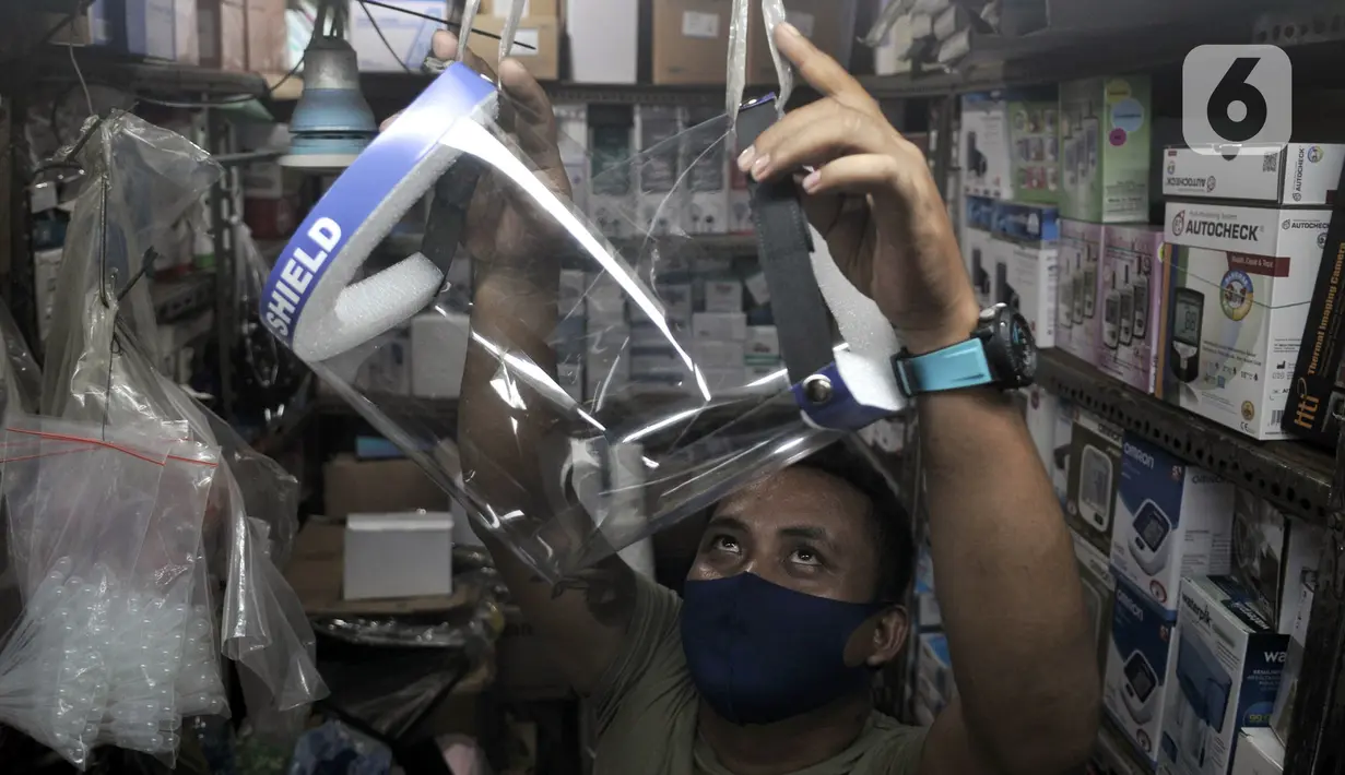 Pedagang merapikan alat pelindung wajah atau face shield di salah satu kios Pasar Pramuka, Jakarta, Rabu (3/6/2020). Jelang pemberlakuan new normal, penjualan face shield meningkat dalam beberapa hari terakhir. (merdeka.com/Iqbal S. Nugroho)
