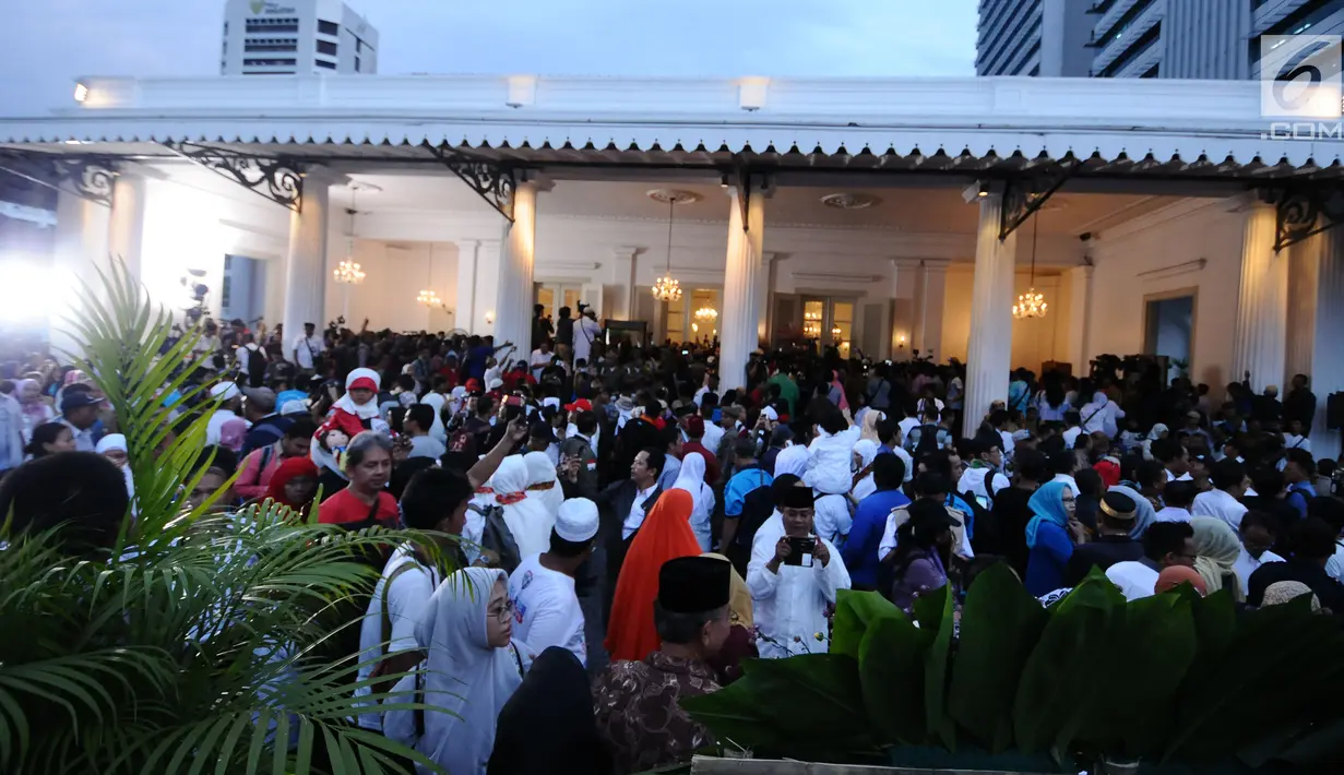 Warga memadati depan gedung Balai Kota Jakarta, Senin (16/10). Ribuan warga menyambut kedatangan Anies Baswedan dan Sandiaga Uno pasca dilantik sebagai Gubernur dan Wakil Gubernur. (Liputan6.com/Helmi Fithriansyah)