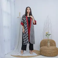 Memadukan dua motif batik berwarna hitam-putih, menghadirkan harmoni visual yang unik. Sentuhan aksen merah pada bagian tepi depan dan ujung lengan menjadi poin statement yang memberi kesan berani dan elegan. [Dok/MAMAUTY]