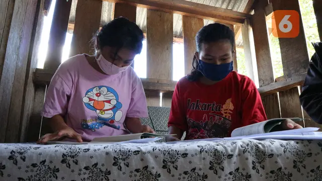 Nolin (15 th) bersama adiknya mengerjakan soal yang diberikan guru sekolahnya.