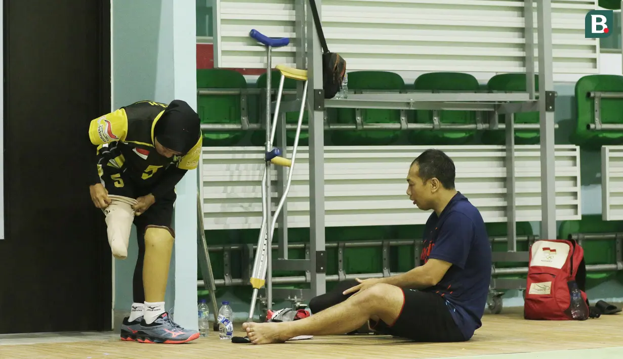 Atlet bola voli duduk Indonesia memasang kaki palsu usai berlatih di Gelora Bung Karno Arena, Jakarta, Kamis (27/9/2018). Latihan tersebut untuk persiapan jelang Asian Para Games 2018. (Bola.com/M Iqbal Ichsan)