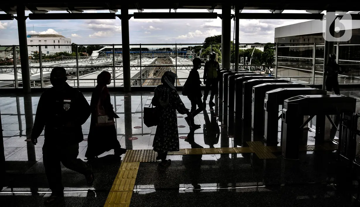 Penumpang kereta Commuter Line melintasi pintu akses yang kini berada di lantai atas Stasiun Jatinegara, Jakarta, Rabu (16/12/2020). Dirjen Perkeretaapian Kemenhub mengoperasikan kembali layanan di Stasiun Jatinegara yang kini memiliki 8 jalur dengan 4 peron.(merdeka.com/Iqbal S. Nugroho)