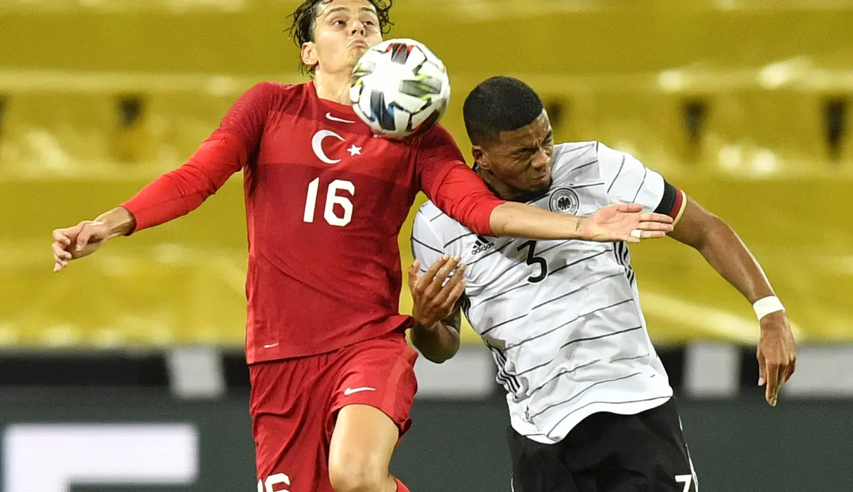 Penyerang Turki, Enes Unal berusaha mengontrol bola dari kawalan bek Jerman, Benjamin Henrichs pada pertandingan persahabatan di Stadion RheinEnergie, Cologne, Kamis  (8/10/2020). Jerman bermain imbang 3-3 atas Turki. (AP Photo/Martin Meissner)