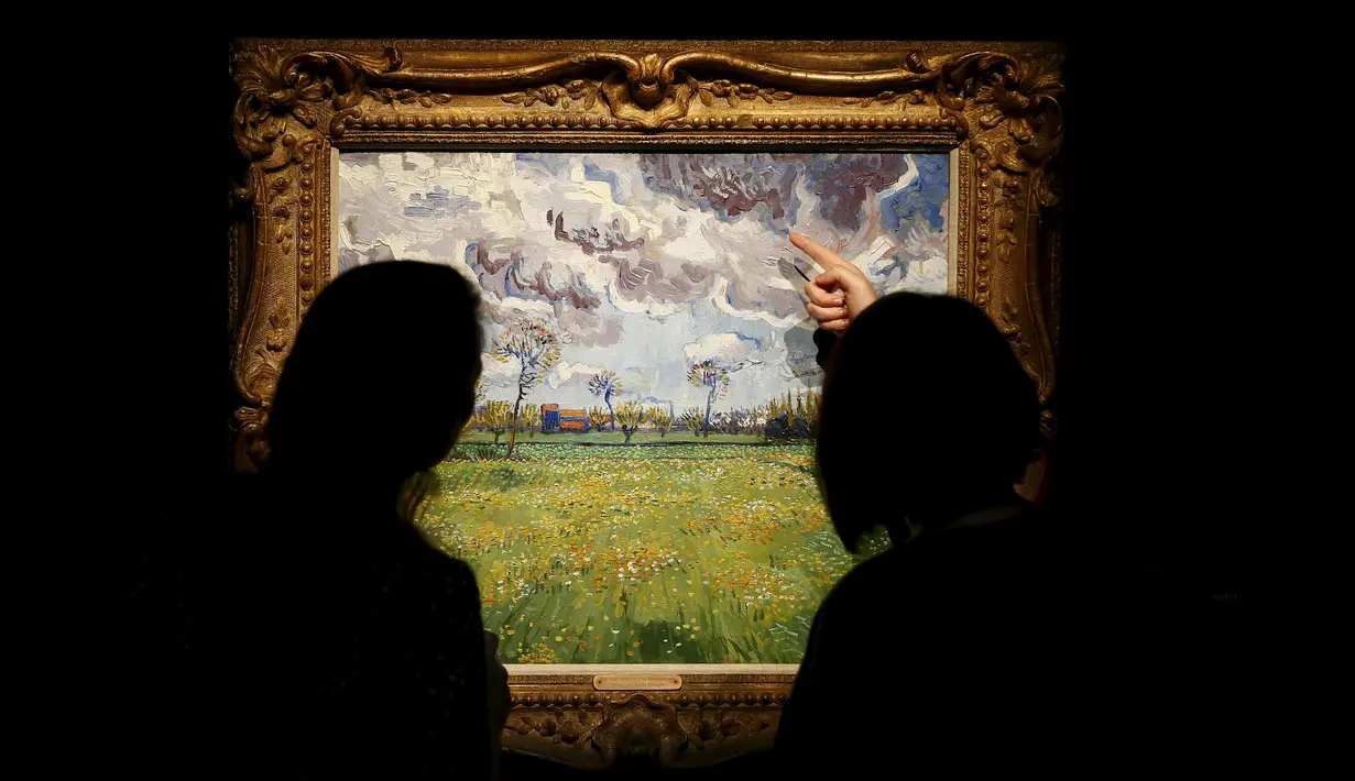 Pengunjung melihat lukisan “Paysage sous un ciel mouvemente" karya Vincent van Gogh di London, Inggris, Jumat (9/10/2015).Lukisan – lukisan ini diperkirakan terjual hingga ratusan miliar rupiah. (REUTERS/Stefan Wermuth) 