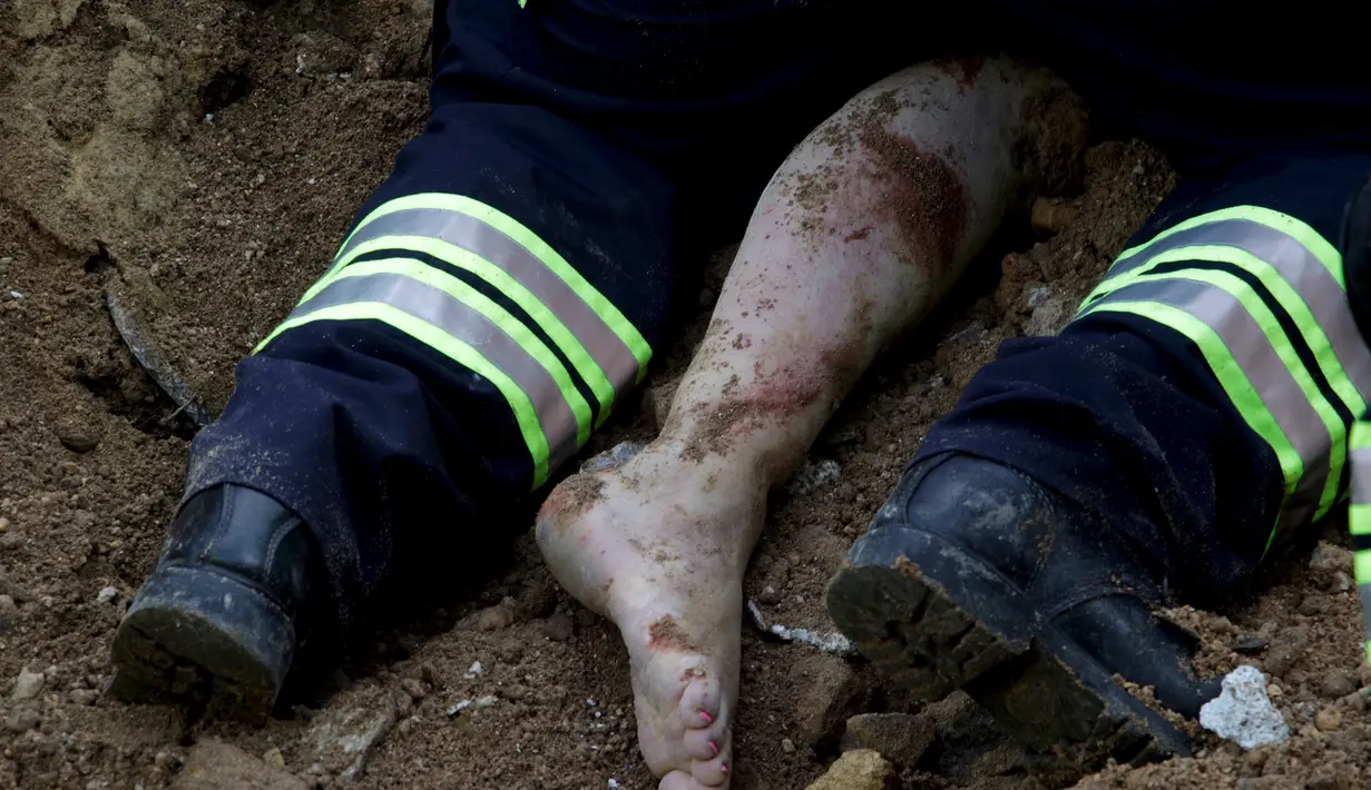 Petugas mendapatkan kaki salah satu korban longsor di Santa Catarina Pinula, Guatemala City (2/10/2015). Musibah tanah longsor ini menewaskan sedikitnya 73 orang dan sebanyak 600 orang dinyatakan hilang. (Reuters/ Josue Decavele)