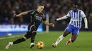 Pemain Arsenal, Leandro Trossard (kiri) berusaha melewati pemain Brighton, Yankuba Minteh dalam laga lanjutan Liga Inggris 2024/2025 di American Express Community Stadium, Brighton, Inggris, Sabtu (04/01/2025). (AP Photo/Ian Walton)