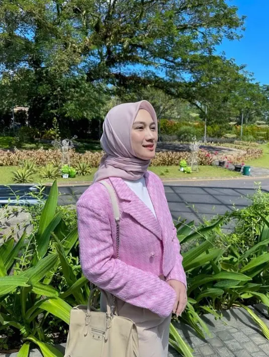 Penampilan Melody kali ini seperti wanita karier dengan inner dan blazer pink. Untuk bawahan, dia memilih warna crem yang senada dengan tasnya. [Instagram/melodylaksani92]