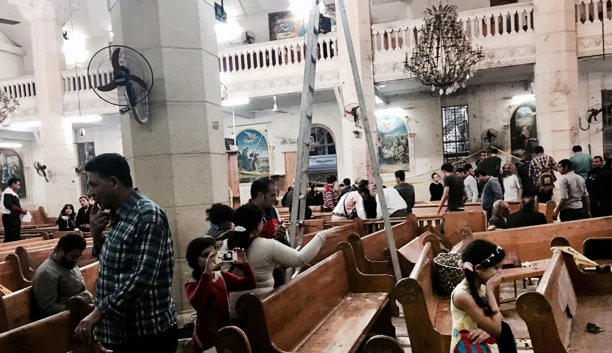 Jemaat mengamati kerusakan Gereja Koptik St. George, Kota Tanta, utara Kairo, setelah ledakan bom, Minggu (9/4). Kelompok yang menamakan diri Negara Islam (ISIS) mengaku bertanggung jawab atas dua serangan bom di gereja Koptik. (AP Photo/Nariman El-Mofty)