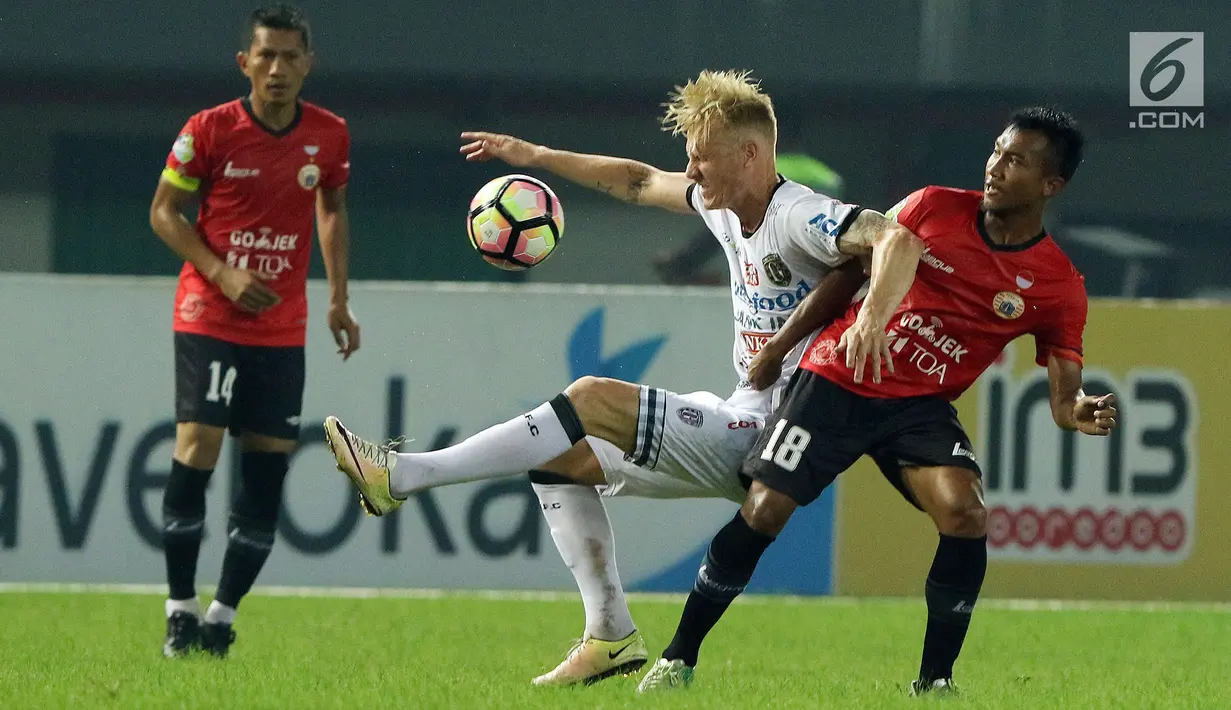 Gelandang Bali United, Nick Van Der Velden (tengah) terjatuih ditahan pemain Persija M Hargianto di lanjutan Liga 1 Indonesia di Stadion Patriot Candrabhaga, Minggu (21/5). Laga kedua tim berakhir imbang 0-0. (Liputan6.com/Helmi Fithriansyah)