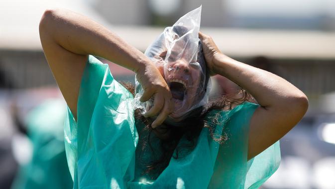 Seorang demonstran yang mewakili pasien tanpa oksigen memprotes Presiden Brasil Jair Bolsonaro dan penanganan virus corona di Brasilia, Minggu (31/1/2021). Covid-19 merenggut lebih dari 223.000 nyawa menjadikan Brasil sebagai negara dengan jumlah kematian terbanyak kedua di dunia. (Sergio LIMA/AFP)