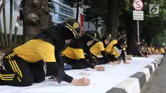 Peserta melukis di atas kanvas selebar 300 meter dalam acara lomba melukis massal di depan Kemenkumham, Jakarta, Minggu (13/8). Kegiatan ini dihadiri 140 murid sekolah dasar dan 320 peserta umum yang berdomisili di Jakarta. (Liputan6.com/Herman Zakharia)
