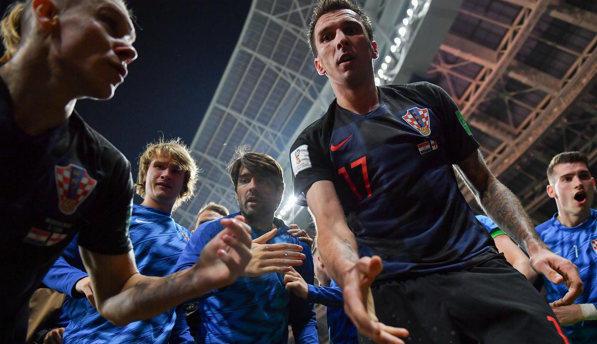 Foto bidikan Yuri Cortez saat Mario Mandzukic menolong dirinya usai selebrasi gol pada semifinal Piala Dunia 2018 di Luzhniki Stadium, Moskow, (11/7/2018). Yuri jatuh saat perayaan gol skuat Vatreni tersebut. (AFP/Yuri Cortez)