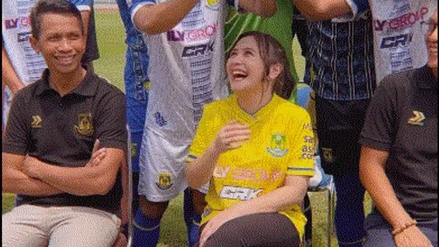 Para Pemain Persikota Tangerang payungi Prilly Latuconsina dengan tangan mereka ketika teriknya matahari saat sesi pemotretan