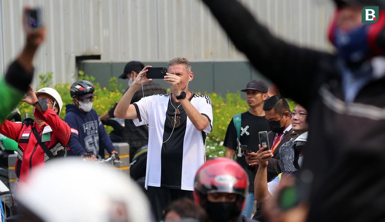 Seorang warga negara asing merekam pawai Kira87uara menggunakan gawainya yang berlangsung dari Kemenpora hingga GBK, Jakarta, Jumat (19/05/2023). (Bola.com/Bagasakra Lazuardi)