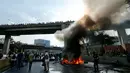 Demonstran dari oposisi membakar ban dan memblokir sebuah jalan di Caracas, Venezuela (24/4). Protes yang terjadi di seluruh Venezuela ini diperkirakan menjadi yang terbesar dalam tiga tahun. (AP Photo/Ariana Cubillos)